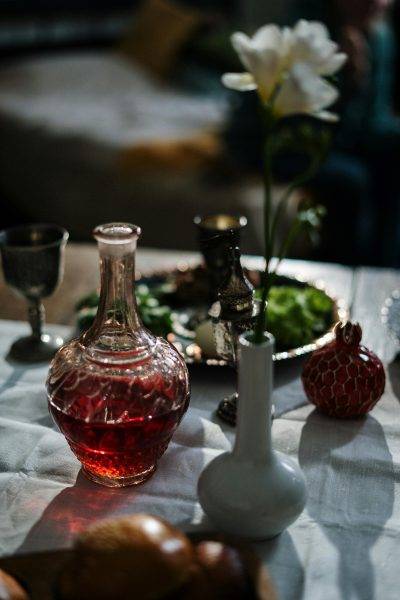 Beautifully set table with a wine decanter and flower in focus, creating a cozy atmosphere